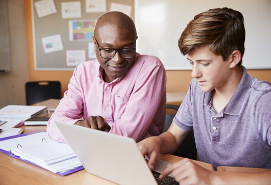 male tutor and student working together