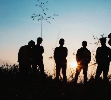 group of young people hanging out in field