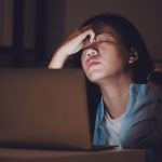 woman sitting at computer looking stressed