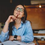 woman sitting at desk thinking