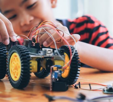 Concentrated boy creating robot at lab.