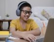 Cheerfully boy excited using computer online learning schoolwork.