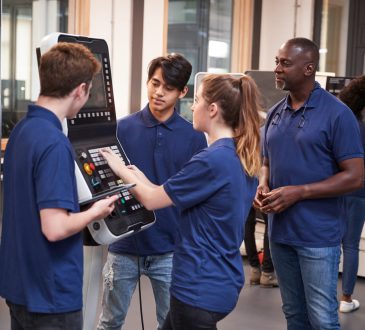 Engineer Showing Apprentices How To Use CNC Tool Making Machine