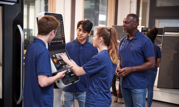 Engineer Showing Apprentices How To Use CNC Tool Making Machine