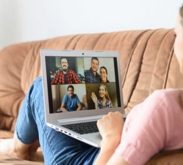 woman sitting on couch during video call on laptop