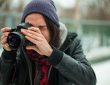 young person taking photo with dslr camera outside