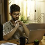 man watching video conference on laptop