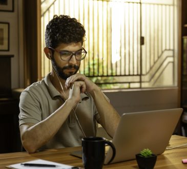 man watching video conference on laptop