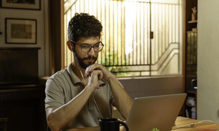 man watching video conference on laptop