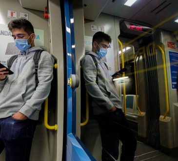 Young man wearing a face mask traveling on the Porto subway