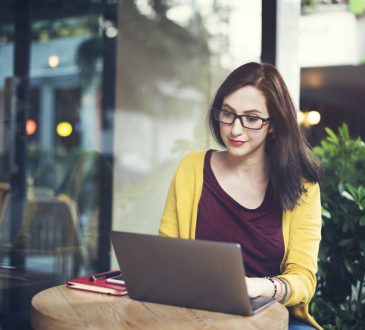 woman using laptop on cafe table