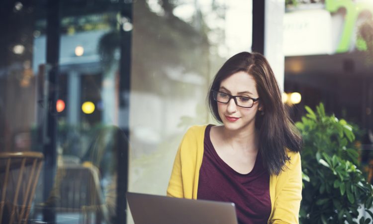 woman using laptop on cafe table