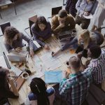 Top view of creative business team sitting at the table at loft office and working.