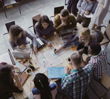 Top view of creative business team sitting at the table at loft office and working.