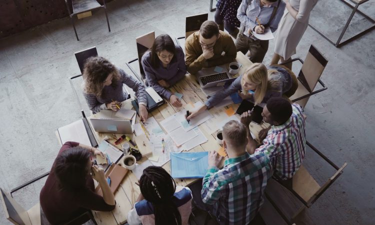Top view of creative business team sitting at the table at loft office and working.