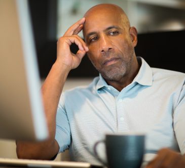 man sitting at desk looking depressed
