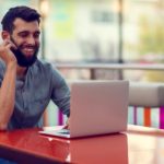 man smiling at laptop