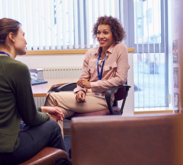 Female College Student Meeting With Campus Counselor