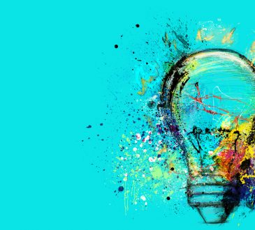 Big stylized light bulb on cyan background drawn with splashes of colored paint.