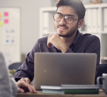 Young man listening to a client in the office