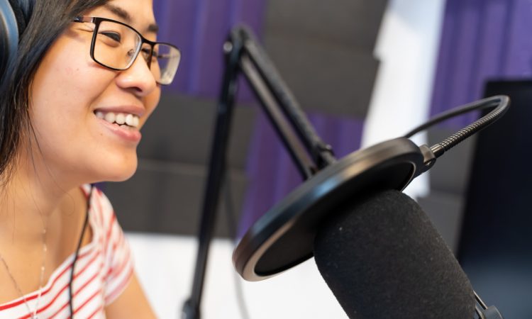 woman recording podcast wearing headphones