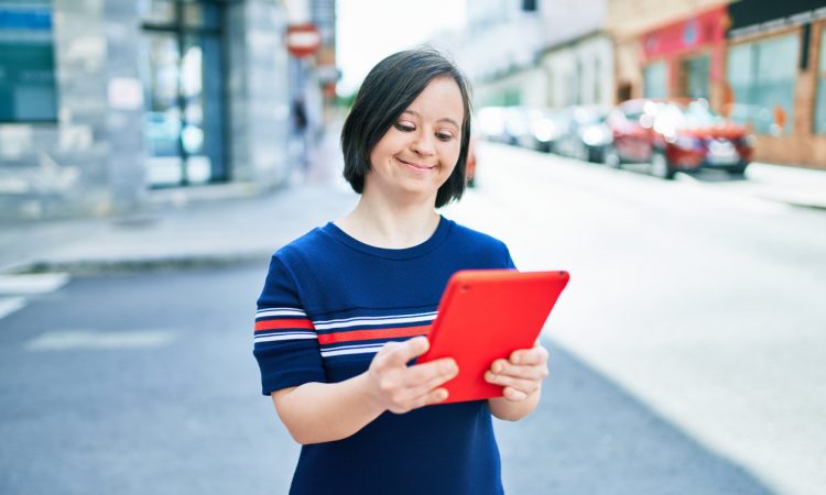woman with down syndrome using tablet outside