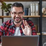 Middle aged man having video call from workplace at home
