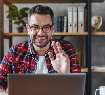Middle aged man having video call from workplace at home
