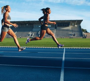 two women sprinting toward finish line on outdoor track