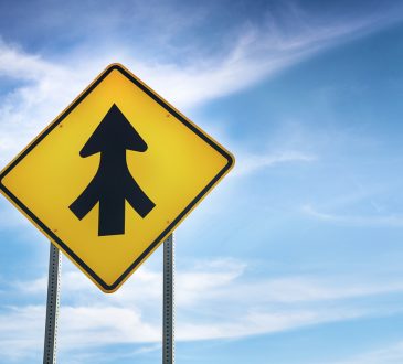 yellow road sign showing three roads merging into one