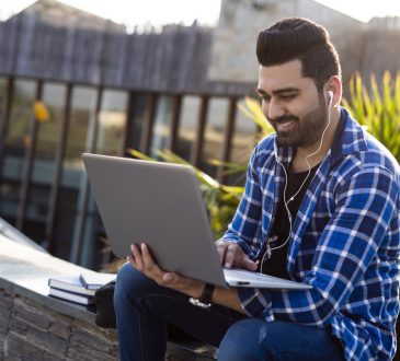 Male student Outdoors on laptop