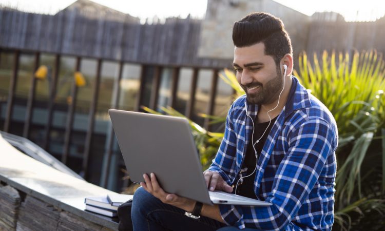 Male student Outdoors on laptop
