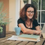 woman working on laptop on table outdoors