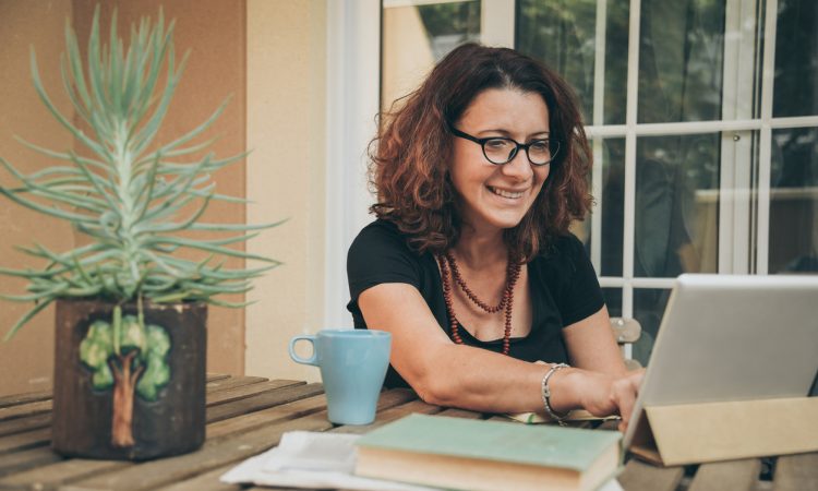 woman working on laptop on table outdoors