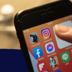 Clubhouse app among other social media icons on smartphone screen
