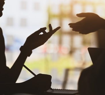 silhouette of two people talking