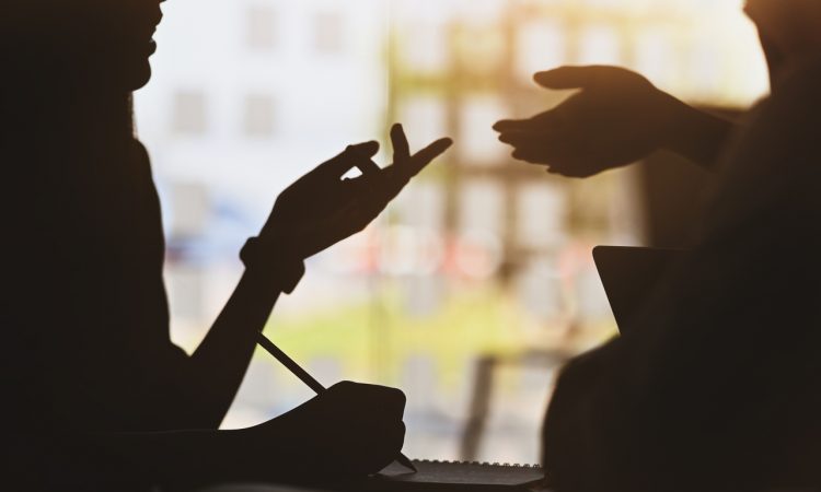 silhouette of two people talking