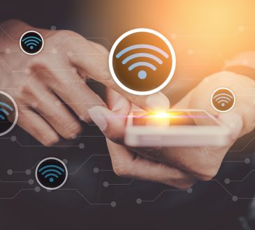 Man hand using smart phone on street with wifi icon and line dot abstract background.