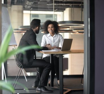 man and woman having meeting in office