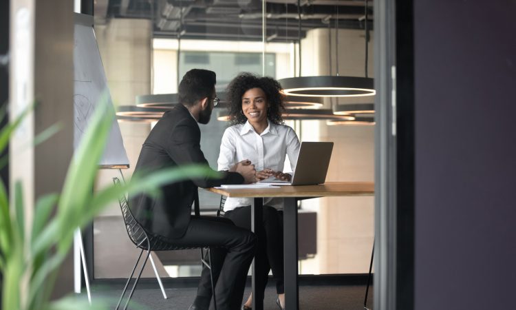 man and woman having meeting in office
