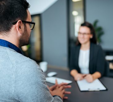 Young male worker being interviewed for a job by a women.