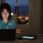 young woman looking at laptop screen suspiciously