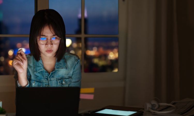 young woman looking at laptop screen suspiciously