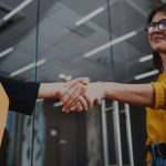 two women shaking hands in office