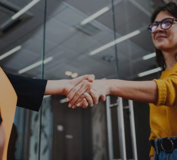 two women shaking hands in office