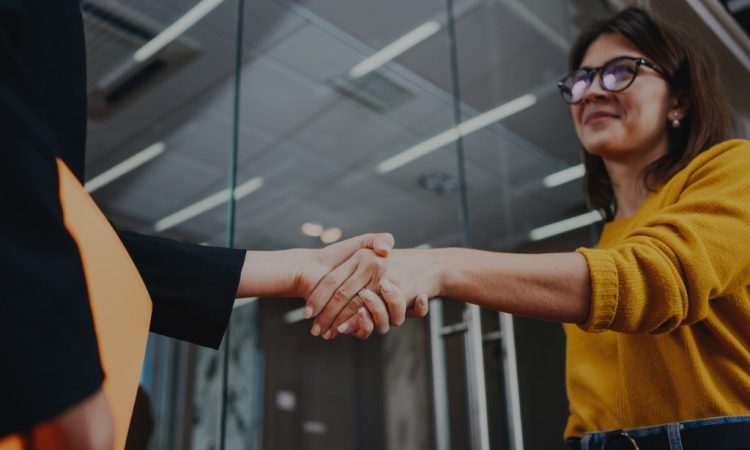 two women shaking hands in office