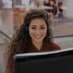 happy female sales agent working at computer