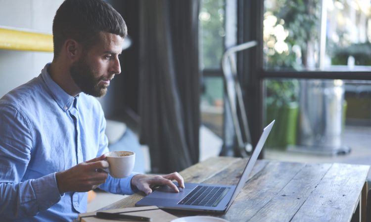 Man watching webinar on laptop.