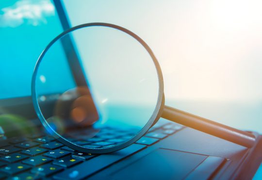 Laptop computer with magnifying glass on keyboard