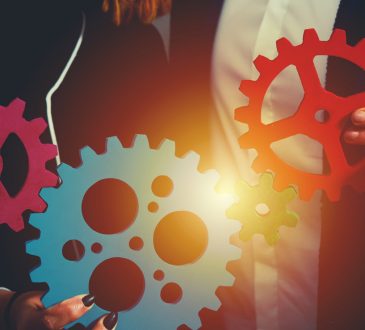 Teamwork of businesspeople work together and combine pieces of gears.